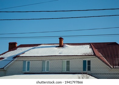 Close-up - A House Made Of White Bricks And A Brown Roof, Against The Background Of A Blue Sky And Black Hanging Electrical Wires