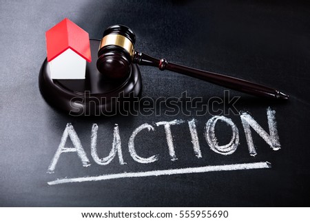 Close-up Of House Model With Gavel On Blackboard