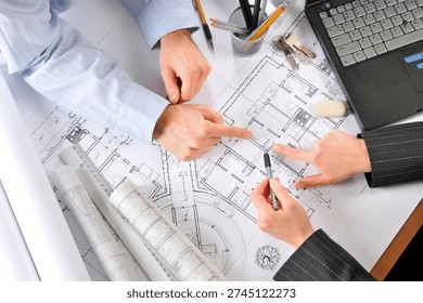 Close-up of House project, Architect's, Developer's, Client's hands. New investments, blueprints, building plans, directly above.