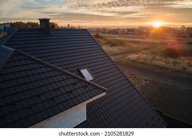 Closeup of house roof top covered with ceramic shingles. Tiled covering of building - Shutterstock ID 2105281829