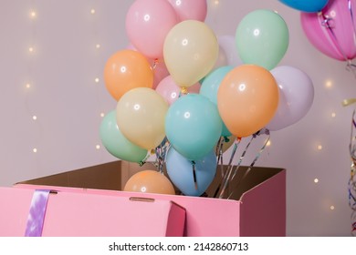 closeup of a huge pink box with colorful balloons inside. birthday present, surprise. holiday goods. High quality photo