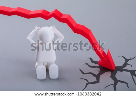 Close-up Of Human Figure Sitting Near Red Arrow Symbol Moving In Downward Direction