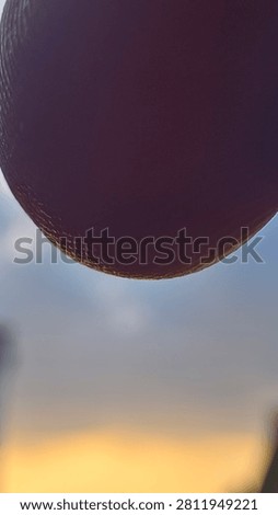 ​Extreme close-up of a human finger blocking the camera lens by mistake, with skin texture visible against a blurred sunset sky background.