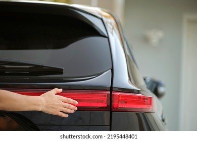 Close-up of human hand on rear car stoplight, checkout before driving. Safety travel concept - Shutterstock ID 2195448401