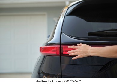 Close-up of human hand on rear car stoplight, checkout before driving. Safety travel concept - Shutterstock ID 2207296671