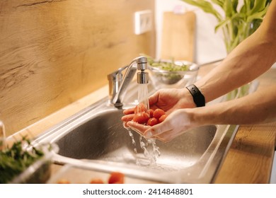 Close-up of human hand take red cherry tomatoes in the kitchen. High quality photo - Powered by Shutterstock