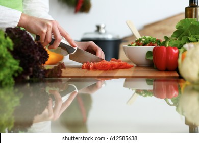 Close-up of human hands cooking vegetables salad in kitchen on the glass table with reflection. Healthy meal and vegetarian concept - Powered by Shutterstock