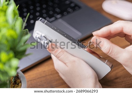 Close-up of human hands inserting a SIM ejector tool into a sleek smartphone, detailing the process for crucial mobile network activation or digital device troubleshooting