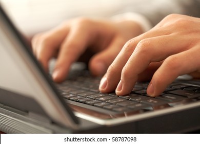 Close-up of human hands pushing keys of laptop or computer