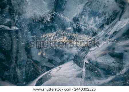 Closeup of Ice inside an ice cave beneath a glacier in Iceland. Particles of golden dust trapped in the ice. 