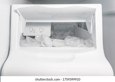 Closeup Of Ice Maker, Machine, In Refrigerator With Ice Cubes. Concept Of Clean Water Filter, Household Appliance Repair, Maintenance And Service