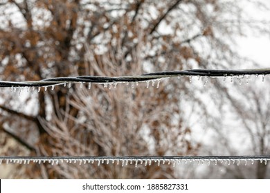 Closeup Of Ice On Power Line From Freezing Rain. Concept Of Winter Storm And Power Outage.