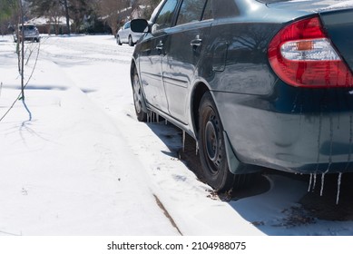 Close-up ice and snow covered on parked cars along residential street near Dallas, Texas, USA. Suburban neighborhood area houses, sidewalk in cold temperature after a historic blizzard cold