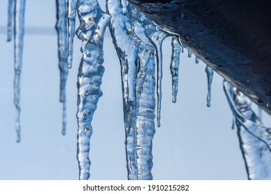 Closeup icicles background. Icicles hanging down from a roof. Cold winter weather, winter season concept