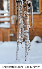 Close-up of Icicles with Cabin in Background