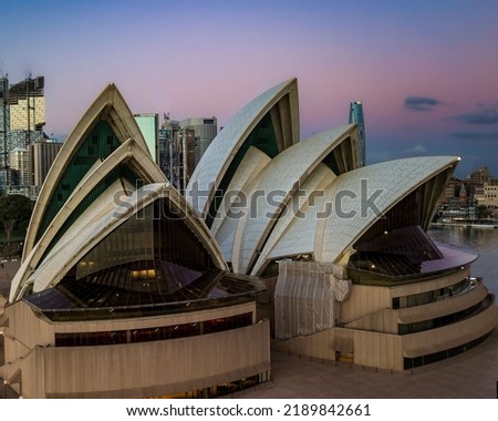 A closeup of iconic world building - Sydney Opera house in full glory at sunset against a colorful sky
