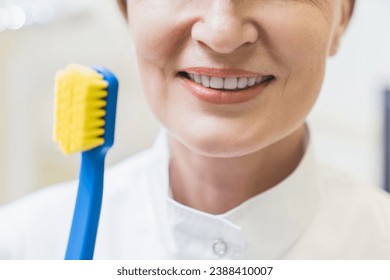 Closeup ideal smile veneers. Orthodontist stomatologist smiling holding tooth brush correctly in dental stomatological clinic hospital - Powered by Shutterstock