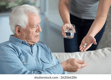 Close-up Of Ill Senior Man Taking Medicine