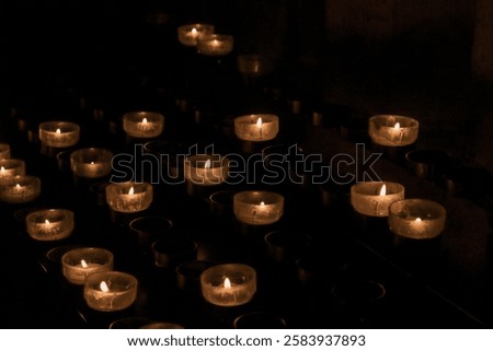 Close-up of illuminated tea light candles against black background