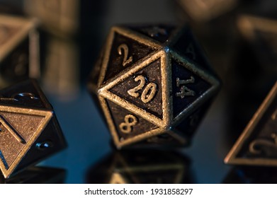A close-up image of a 20-sided rpg die on a reflective surface with in the background the other dice of the set.