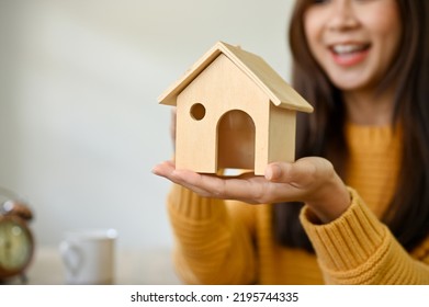 Close-up Image, A Beautiful Asian Female Putting A House Model On Her Hands. Real Estate Agent, Property Investment, Rental, Home Buyer Concept.