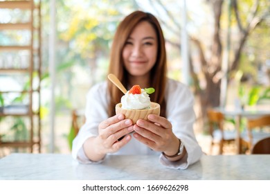 Closeup Image Of A Beautiful Asian Woman Showing And Eating An Ice Cream In Restaurant