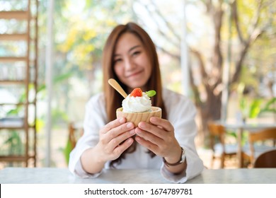 Closeup Image Of A Beautiful Asian Woman Showing And Eating An Ice Cream In Restaurant