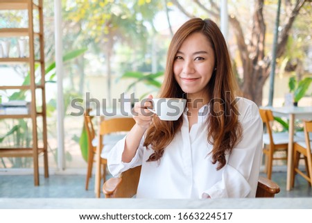 Similar – Foto Bild Eine Frau, die hinter einer halboffenen Tür Kaffee genießt.