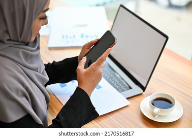 Close-up Image, Beautiful Muslim Woman Wearing Hijab, At Hr Office Desk Using A Smartphone, Chatting With Someone.