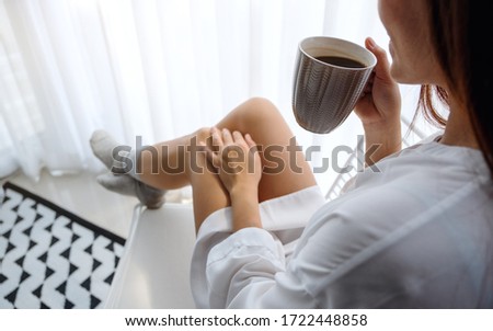 Closeup image of a beautiful woman drinking hot coffee in bedroom at home in the morning