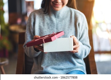 Closeup Image Of A Beautiful Young Woman Opening A Gift Box 