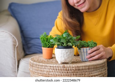 Closeup image of a beautiful young woman looking and taking care of houseplants at home - Shutterstock ID 2222348679