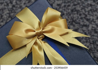 closeup image of blue gilt box with golden ribbon - Shutterstock ID 253906459