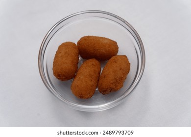 A close-up image of a bowl filled with a selection of corn dogs and accompanying dipping sauces - Powered by Shutterstock