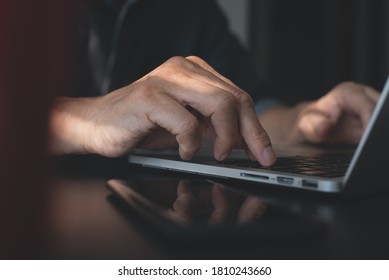 Closeup Image Of A Business Man's Hands Working And Typing On Laptop Computer Keyboard With Mobile Smart Phone On Wooden Table, Online Working From Home, Portable Office Concept