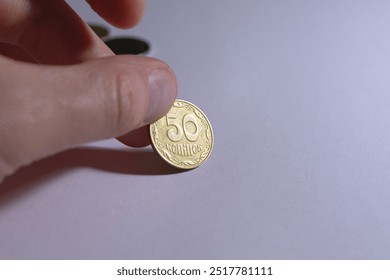 Close-up image capturing a human hand holding a 50 kopeks coin, showcasing currency, finance, and savings concept. Ideal for economic articles and financial themes.