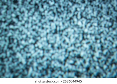 A close-up image capturing static noise present on a television screen. The image highlights a random pattern of black and white dots, creating an abstract visual effect.