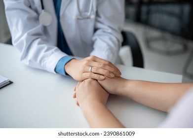 Close-up image of a caring and kind doctor holding a patient's hands to comfort and reassure them during a medical checkup at the hospital. - Powered by Shutterstock