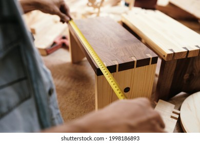 Close-up Image Of Carpenter Measuring Drawer Front With Tape Measure