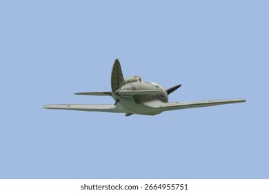 Close-up image of a classic single-engine propeller airplane in flight against a clear blue sky, depicted at an angle to show both front and side profile The aircrafts fuselage, tail assembly, wing