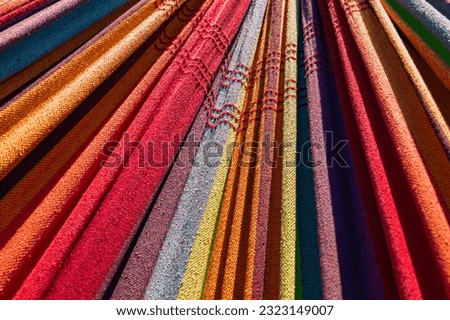 A close-up image of the colorful cloth of a hammock