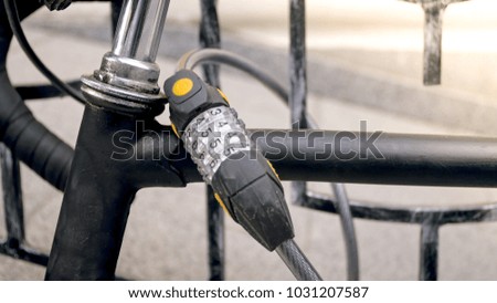 Closeup image of combintaion lock on old black bicycle