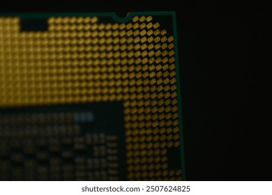 A close-up image of a computer CPU Tech innovation, focusing on the detailed array of gold-colored contact pins and the intricate grid pattern on the processor’s surface.