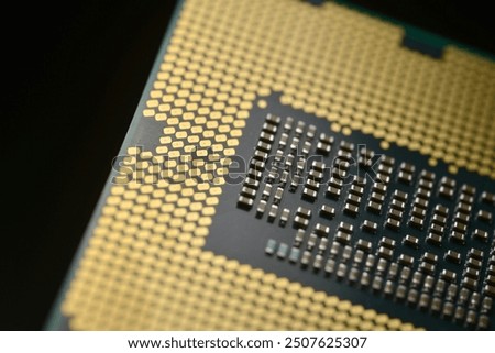 A close-up image of a computer Nanotechnology, focusing on the detailed array of gold-colored contact pins and the intricate grid pattern on the processor’s surface.