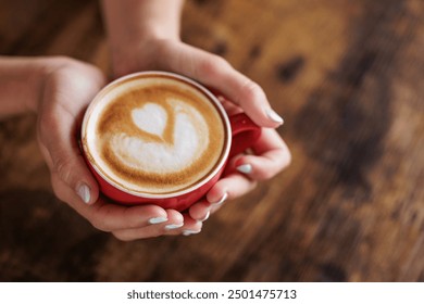 Close-up image of a cup of coffee held in hands. Nothing like a good coffee to start the day. Hand-roasted coffee, authentic coffee. A dose of caffeine. Portrait