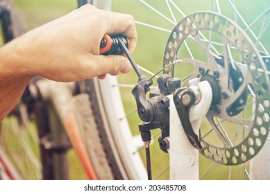 Close-up image of cyclist's hand repairs wheel of bicycle - Powered by Shutterstock