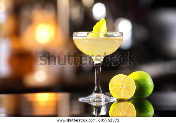 Closeup image of daiquiri cocktail decorated\
with lemon at bar counter\
background.