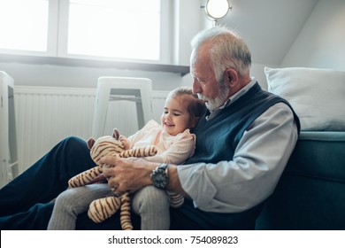 Close-up image of an elderly man holding his granddaughter