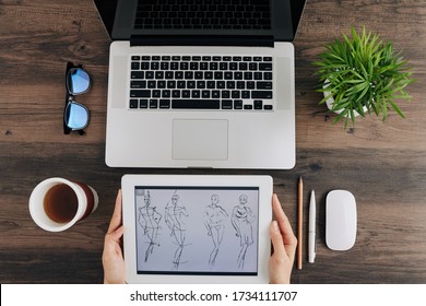 Close-up image of fashion designer uploading his sketch from tablet computer to laptop - Powered by Shutterstock