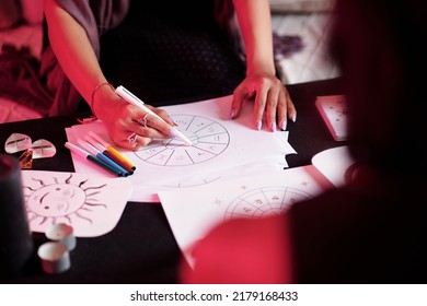 Closeup image of female astrologer drawing natal card for female client - Shutterstock ID 2179168433
